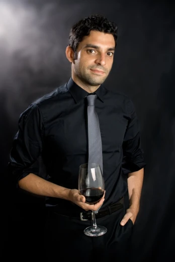 man posing with wine glass and tie