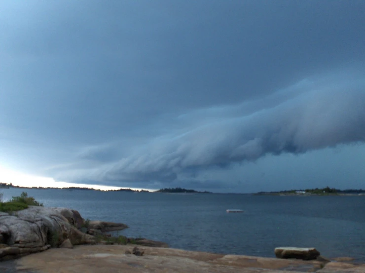 a storm clouds moving towards the ocean and land