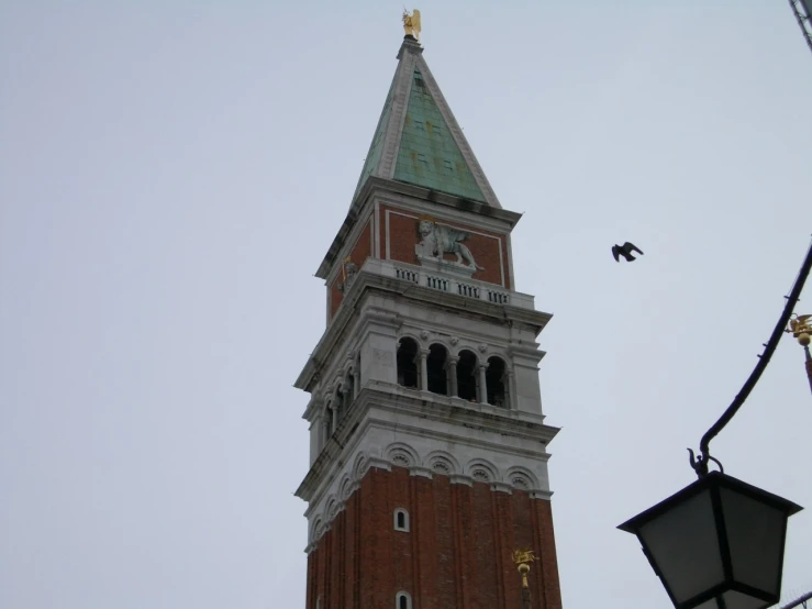 a clock tower with some birds flying overhead