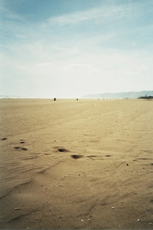 footprints in the sand on an open area