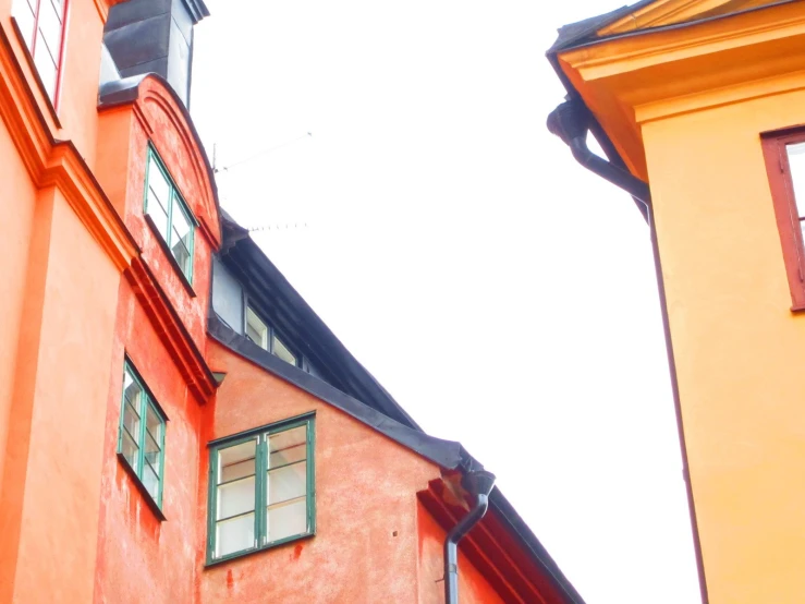 the view of the windows and roof of two orange buildings