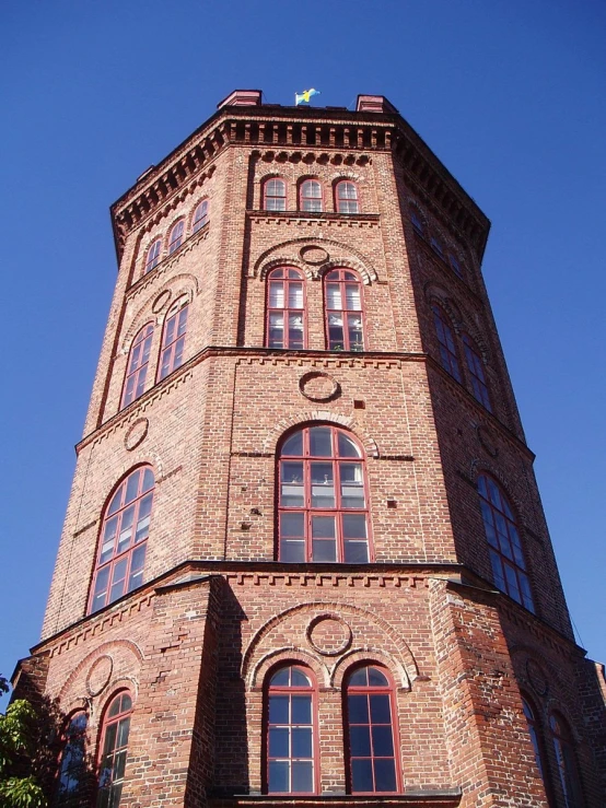 a tall red brick building with an orange top