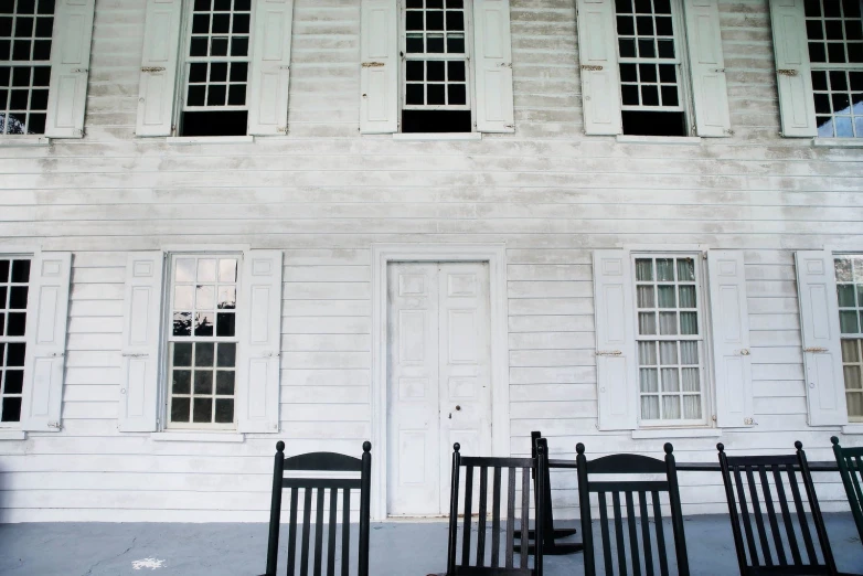 white houses with black chairs sitting outside of them