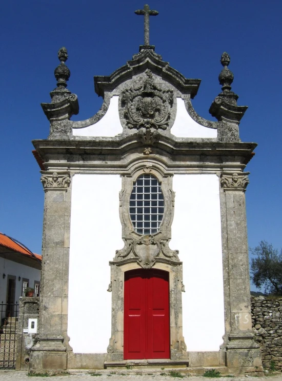 a stone building with a door and cross above it
