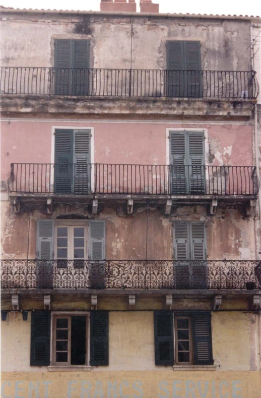 balcony on an old building with windows and iron railings