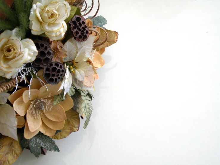 a flower arrangement with white roses and brown leaves