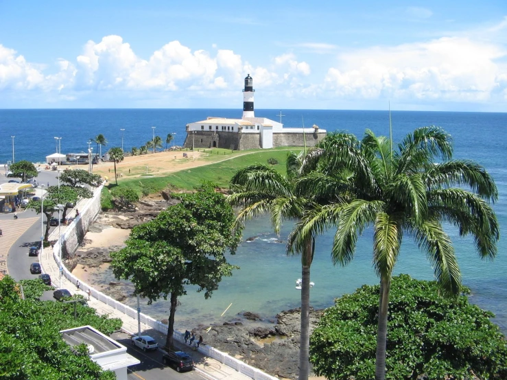 a view from a balcony overlooking the ocean with a lighthouse in the background