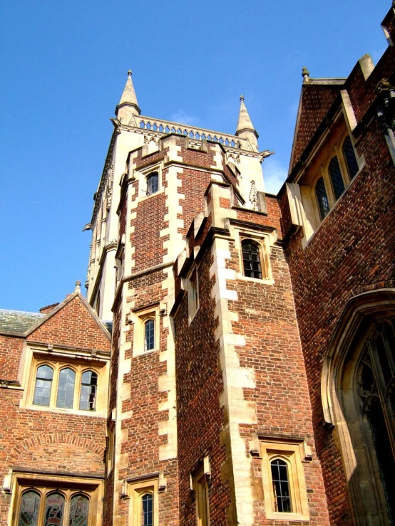 a tall brick clock tower with windows on a sunny day