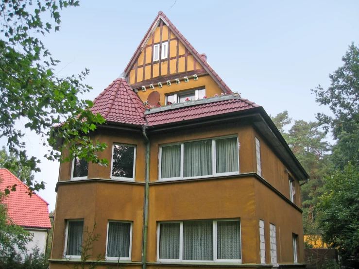 a very tall orange colored house in a neighborhood