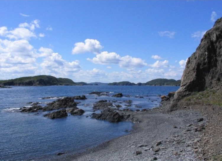 a small rocky shore at the edge of the ocean