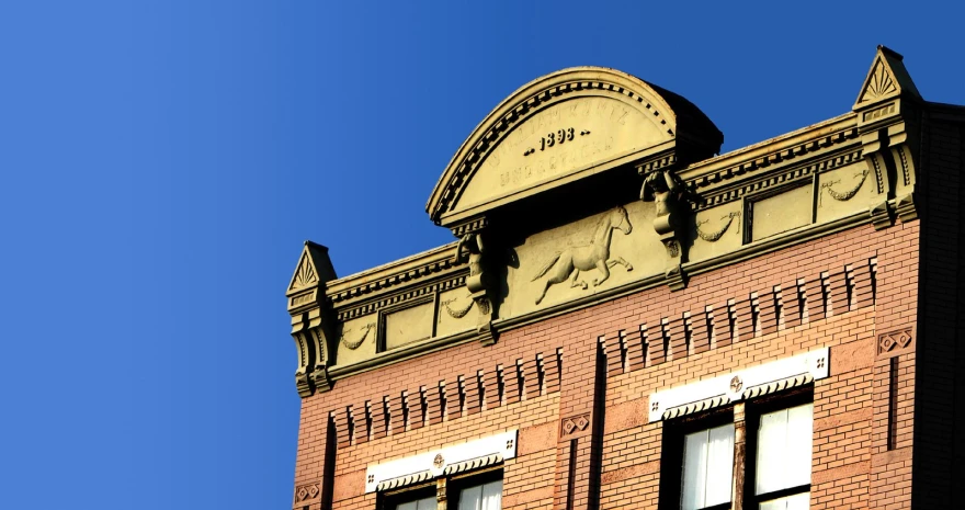 a large brown brick building with a clock on the top