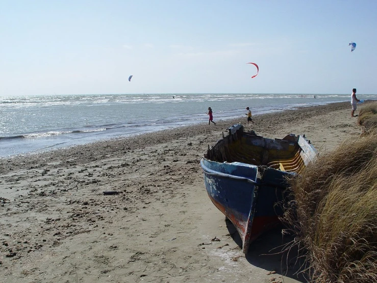 there are people and boats on the beach