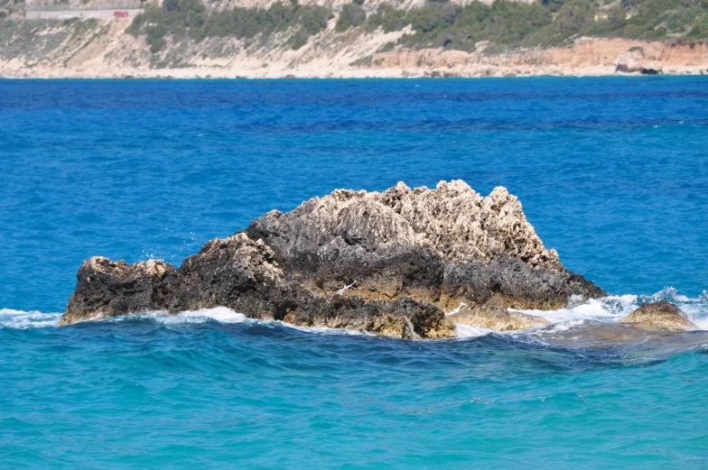 rocks sitting in the water on an island