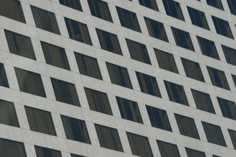 a large grey building with many windows and birds standing in the window