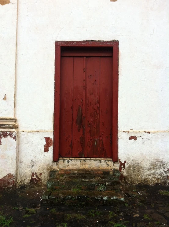 an old red door is opened to reveal another open door