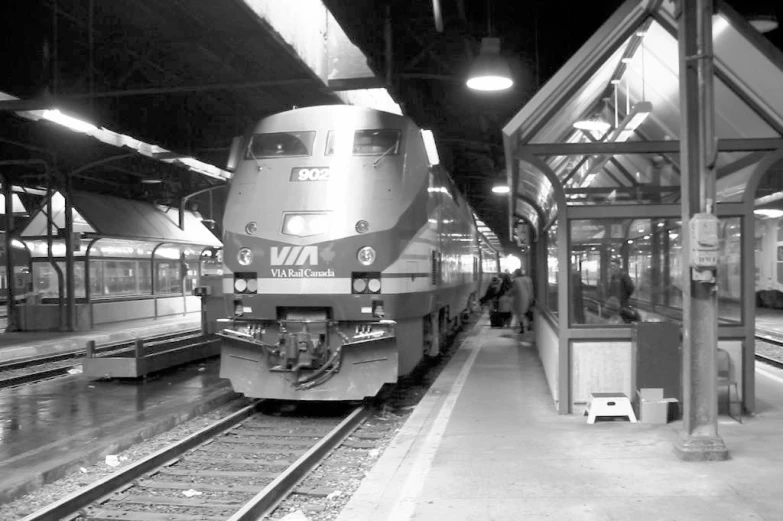 a train pulling into the station with people waiting