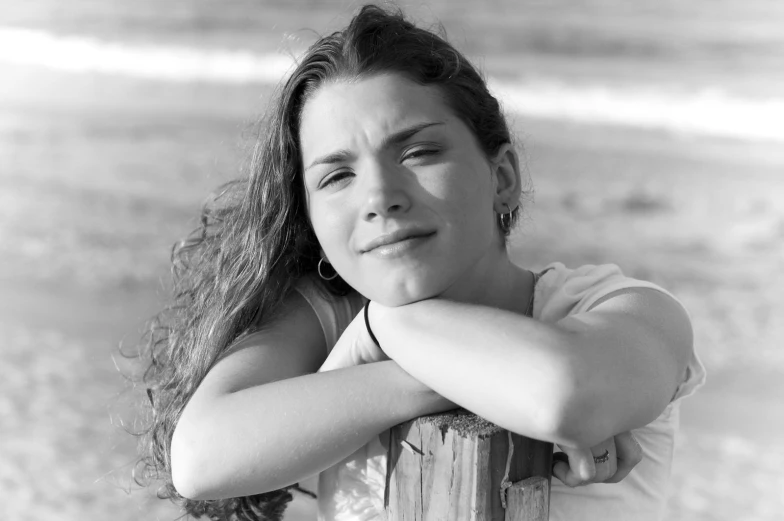 a black and white po of a woman leaning against a fence