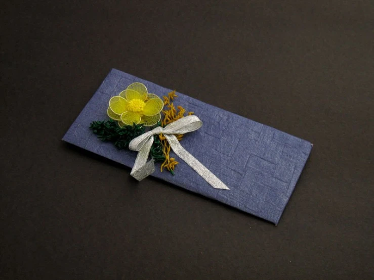 a bouquet of flowers on a napkin with white ribbons