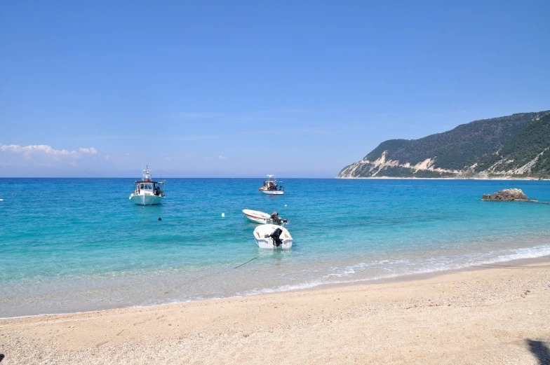 boats on the ocean, and sand and rock