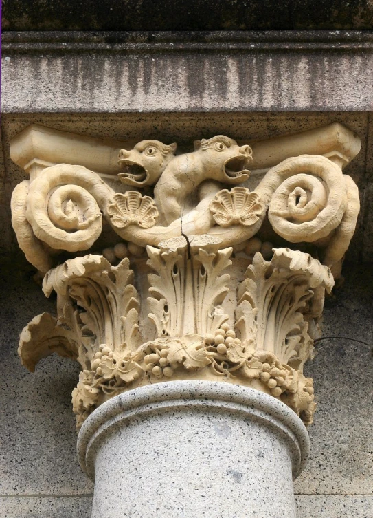 a stone corinched column with a carved squirrel and gs design