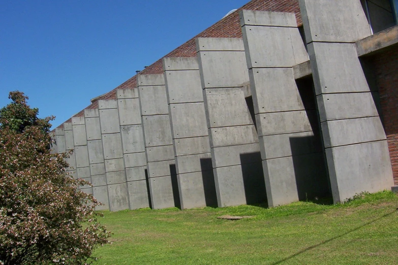 there is a large stone building with two green trees in front of it