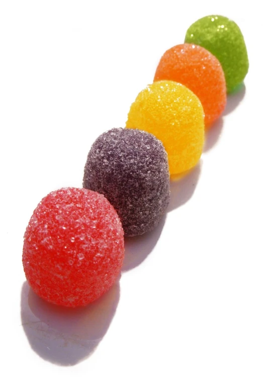 a line of colorful candies on a white surface