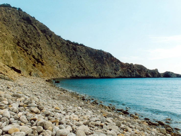 some water rocks and a large cliff next to it