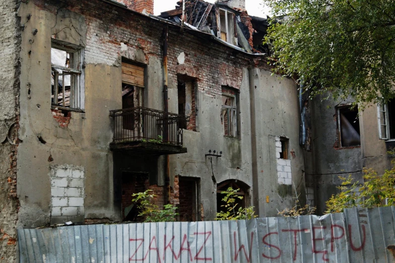 an old run down building with graffiti in the foreground