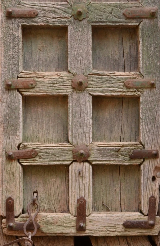 a rustic door with metal latches is shown