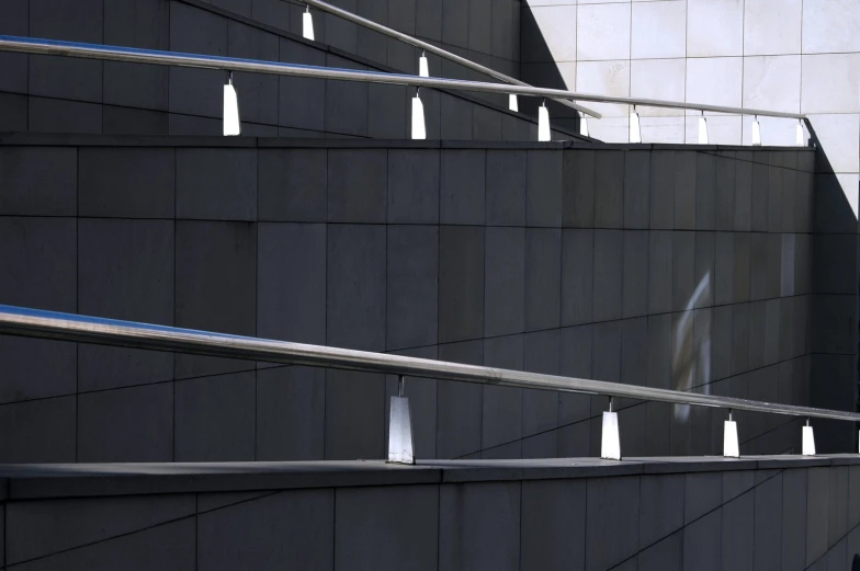 several metal stairs lined up against a concrete wall