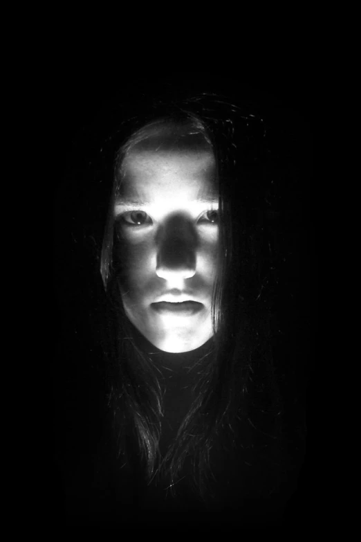 a woman's face glowing from a window