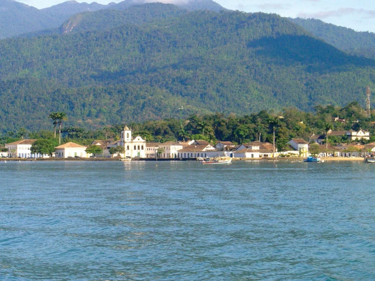 a beautiful resort on the shore surrounded by green mountains