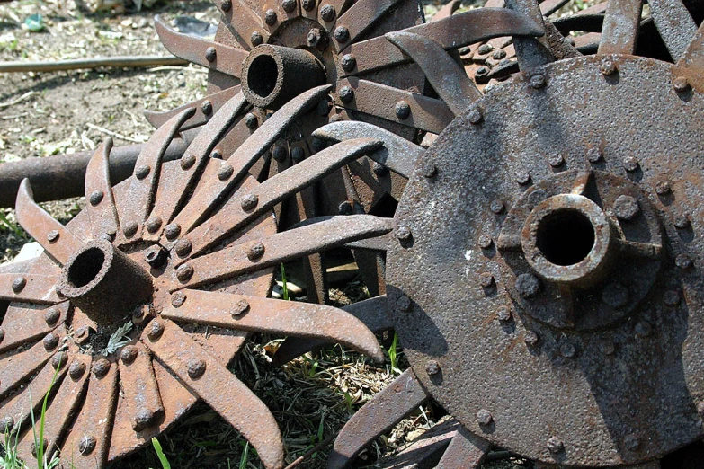 a couple of rusty and weathered wheels laying in a field