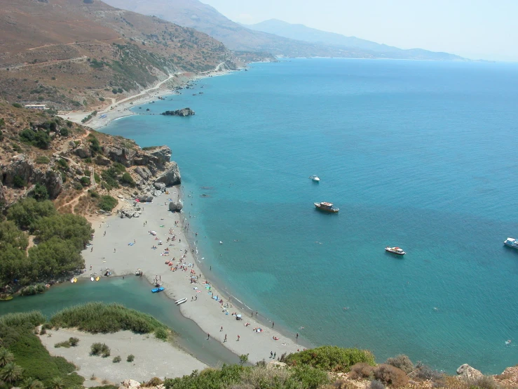 a beach with two canoes in the ocean