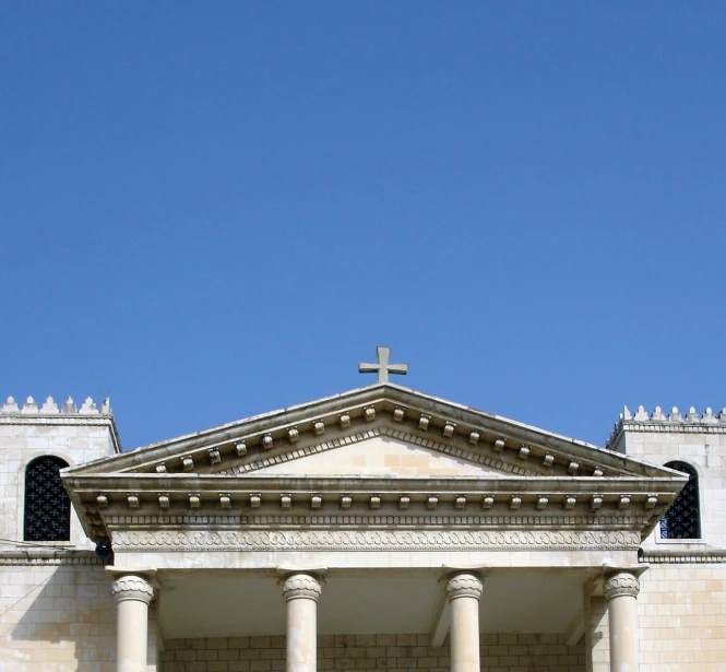 a cross is above the roof of an old stone church