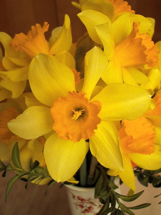 some yellow flowers in a white and blue vase