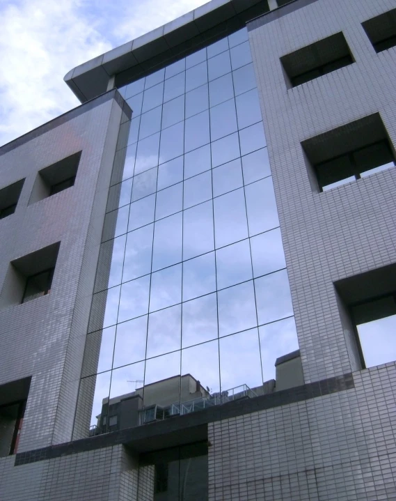 the windows are reflecting buildings and clouds