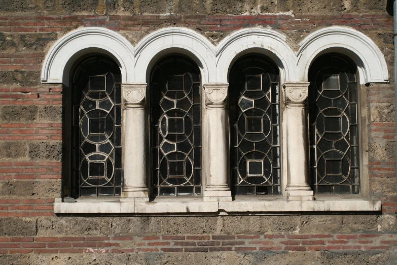 an old, vintage stone window with black iron grilles