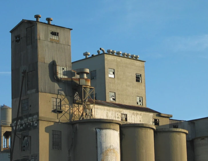 a very old industrial building has a large grain silo