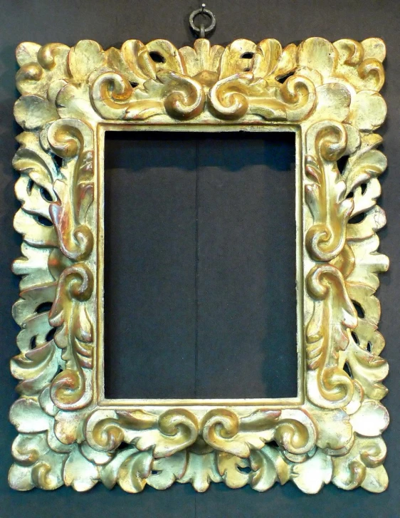 a gold frame mounted to a black wall