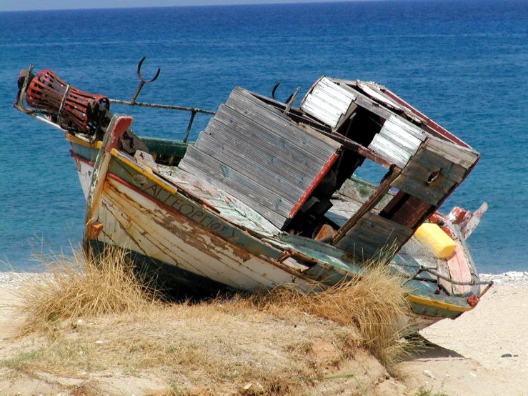 an old ship with its broken sails is sitting on the beach