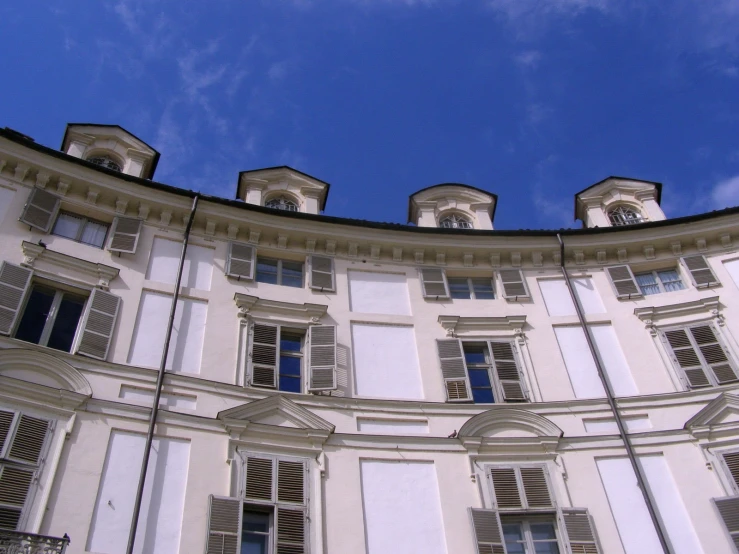 several white windows sitting on the side of a large building