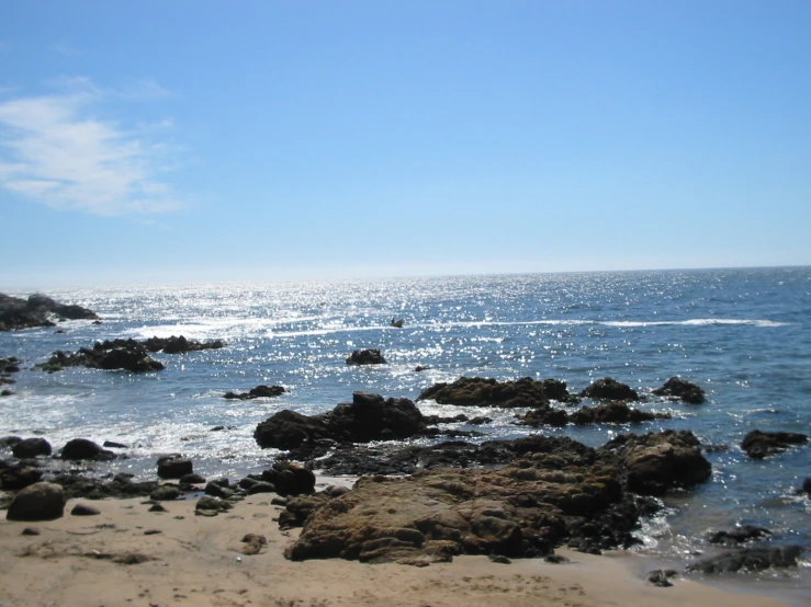 the shoreline of a beach with rocks in it