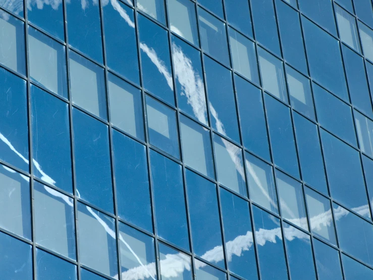 a building that has lots of windows and sky reflection