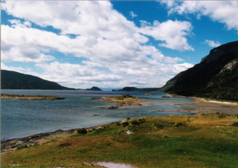 a river surrounded by lush green mountains under blue sky