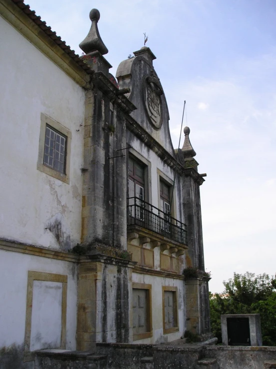 an old white building with stairs leading up to it