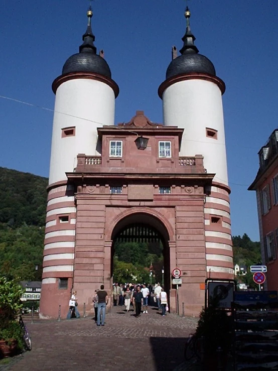 several people walk under a tall, round structure