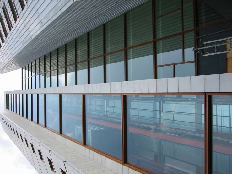 an upper level building that has many windows reflecting in the glass