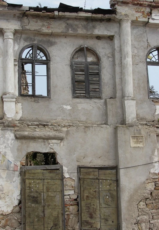 a run down building with a couple doors that look like it's going down