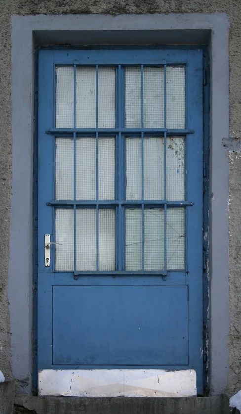 the blue door is against the stucco wall